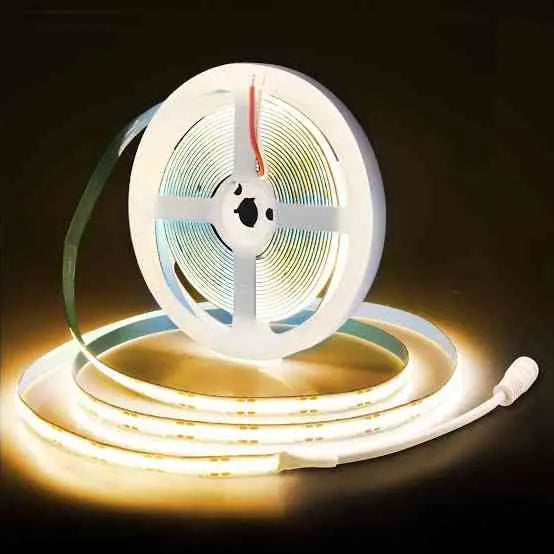 Strippy 3000K COB LED Light Strip on reel with Easy Connect DC plug, emitting warm white glow for home lighting applications.