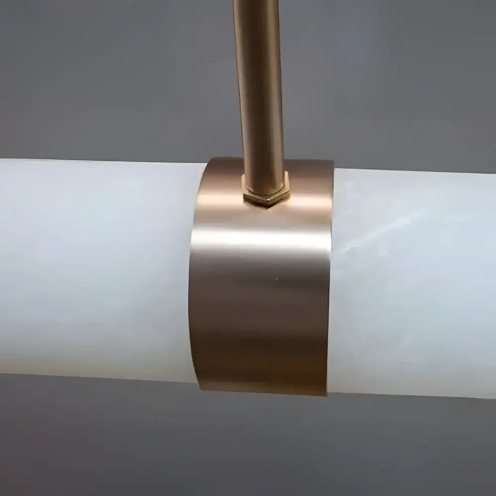 Close-up of a cylindrical light fixture with a bronze band on a gray background