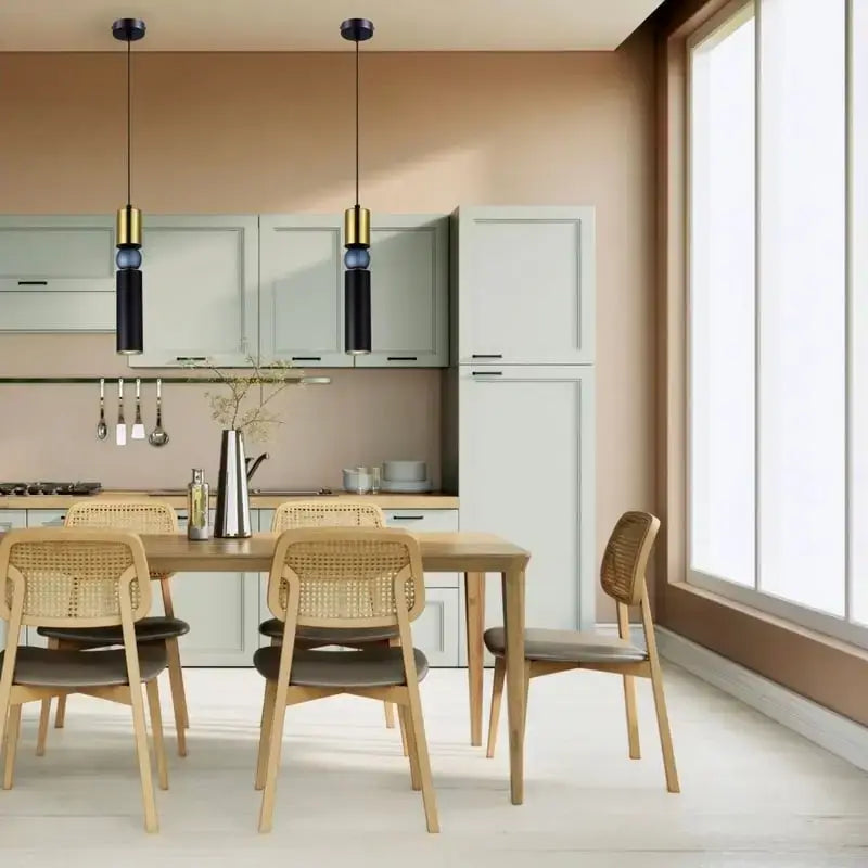 Modern kitchen with dining area featuring wooden table and chairs. Modern dining room with wooden table and chairs, pendant light, and decorative plant. Roma Matt Black & Brass LED Tri-Colour Single Pendant Light